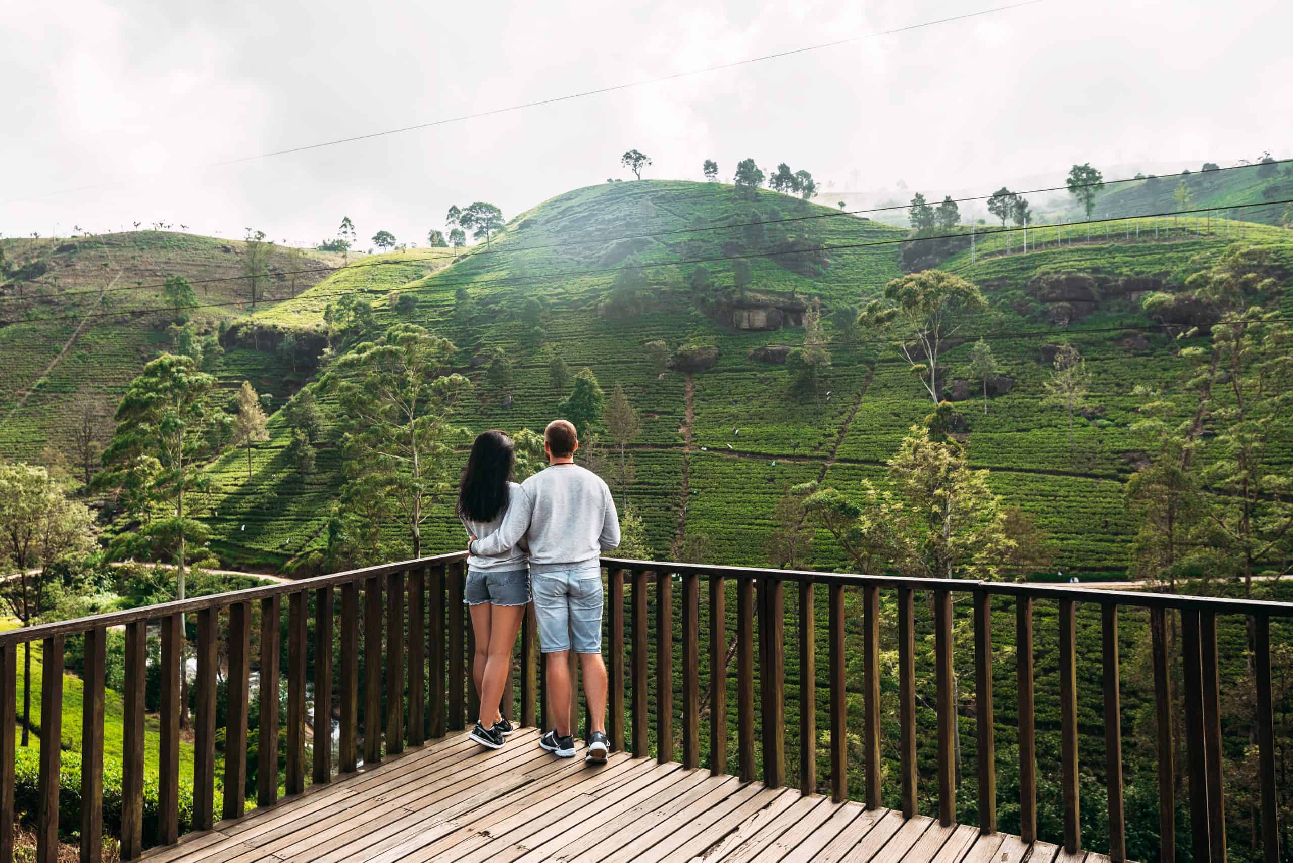 Couple in love at tea plantation. Travel to Sri Lanka. Green tea plantations in the mountains. Guy and girl traveling around Asia. Man and woman traveling. Tea plantations in Sri Lanka. Loving couple